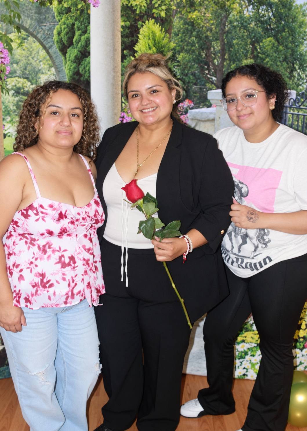 Three women celebrating together with a rose