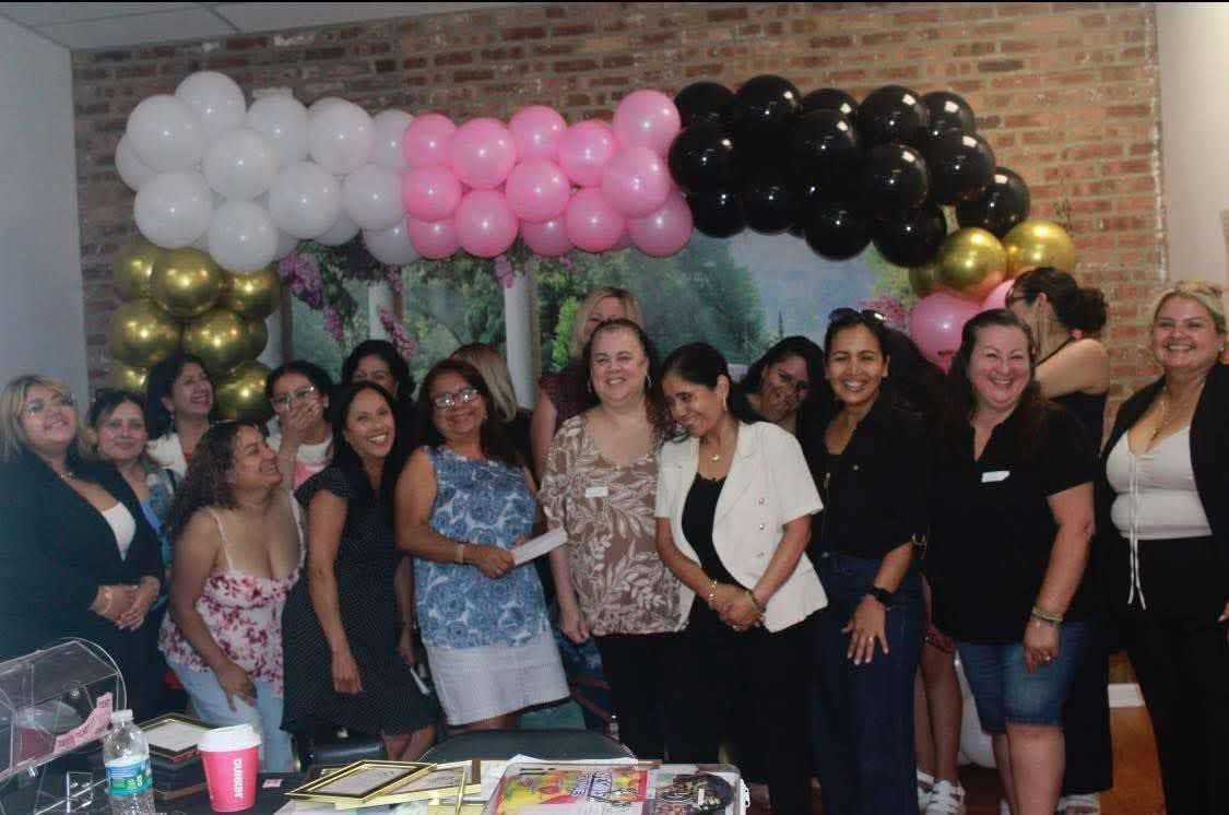 The women of Nika's Reign gathered beneath the balloon arch at the launch reception