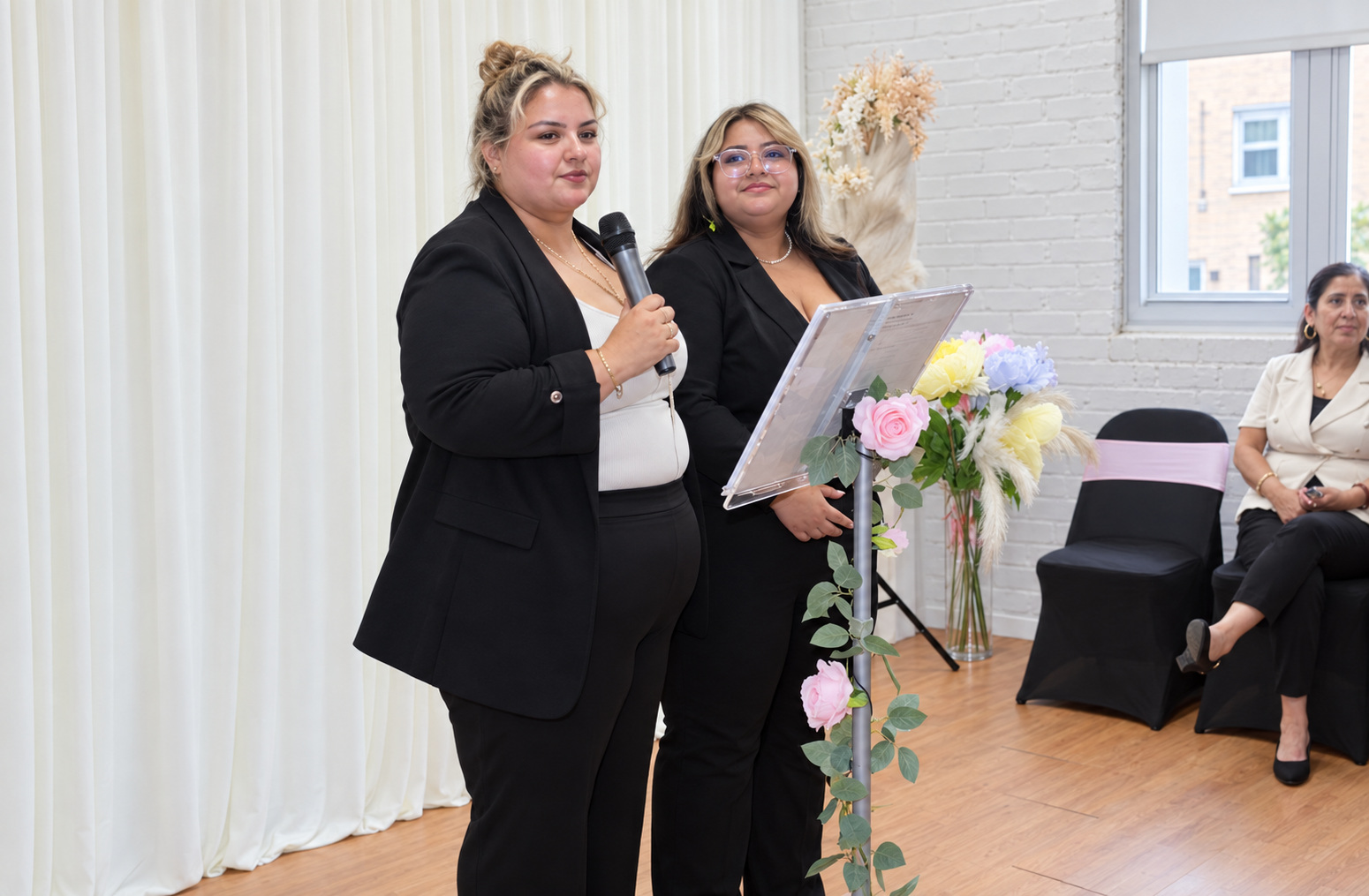 Two women sharing the lectern at the reception